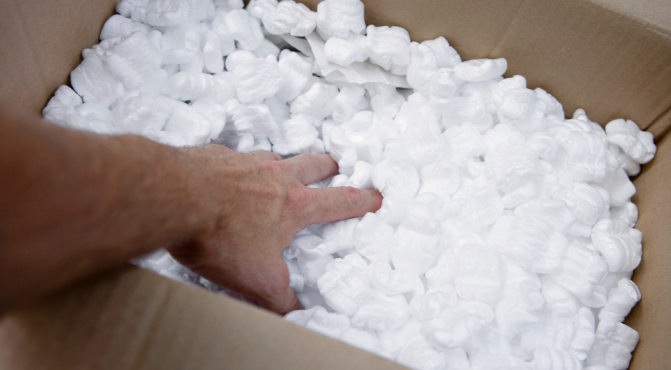 hand reaching into a box of packing peanuts