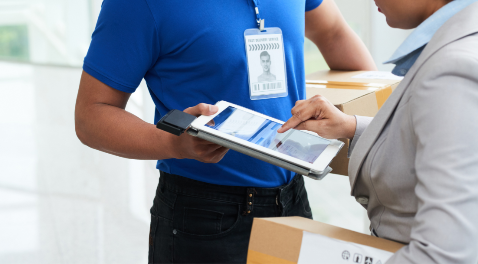 A customer holding a parcel confirming a charge for fast track delivery