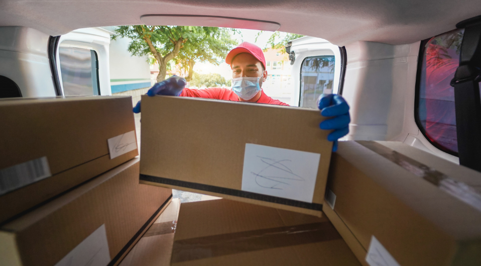 courier loading parcels into the back of a van