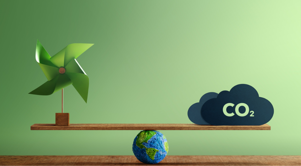 A piece of wood resting on top of a small model of planet Earth with 'CO2' on one side and a wind spinner on the other