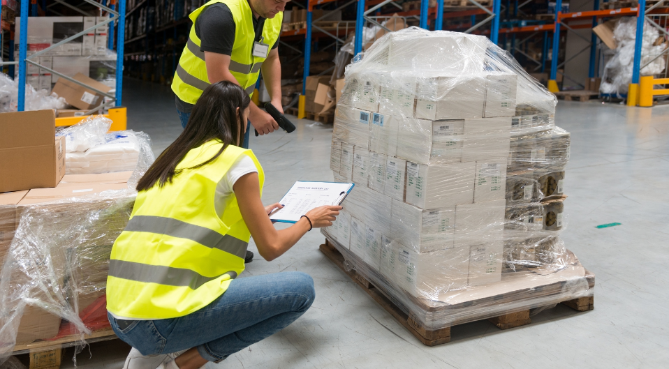 Warehouse workers checking documentation on parcels