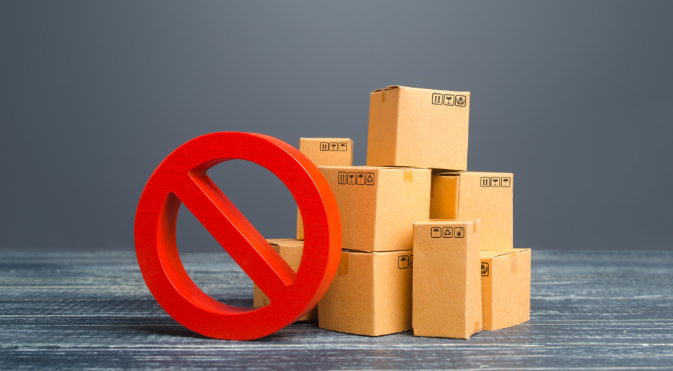 Cardboard boxes stacked next to a red circle symbol with a line cutting through it